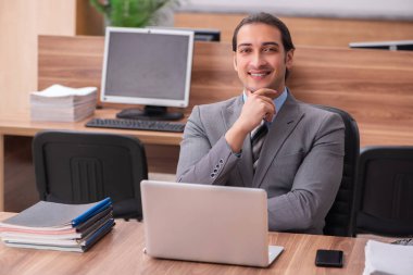 Ofiste çalışan genç bir erkek.