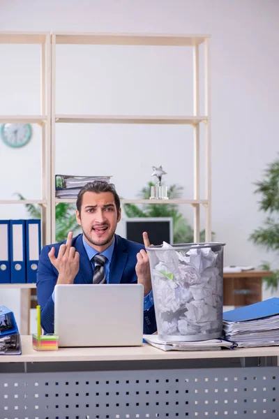 Ung affärsman anställd avvisa nya idéer med massor av pape — Stockfoto