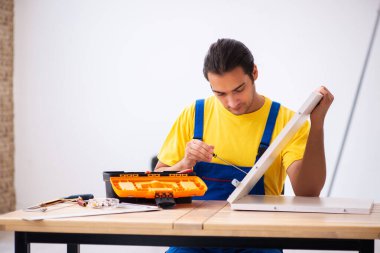 Genç erkek marangoz içeride çalışıyor.