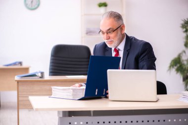 Ofiste oturan eski bir işadamı.