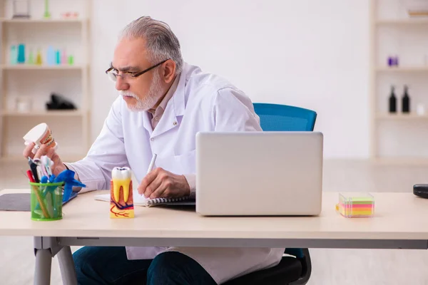 Viejo dentista masculino que trabaja en la clínica —  Fotos de Stock