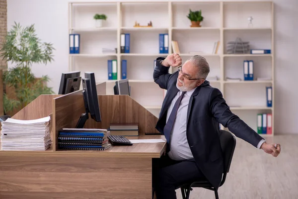 Velho empregador masculino e muito trabalho no escritório — Fotografia de Stock