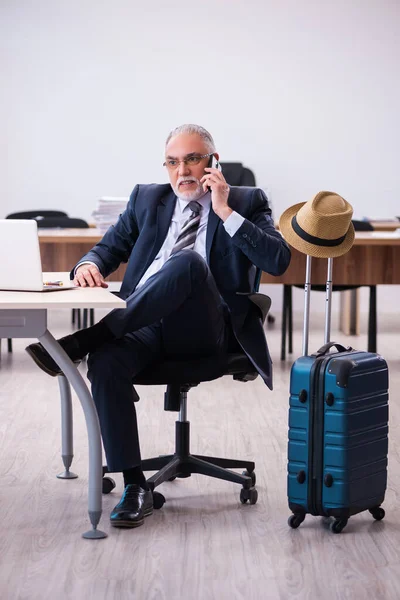 Velho funcionário do sexo masculino se preparando para viajar no escritório — Fotografia de Stock