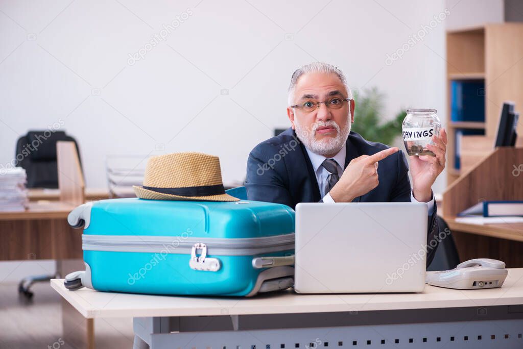 Old male employee preparing for travel in the office