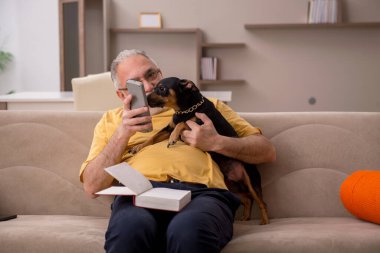 Evde köpeği olan yaşlı bir adam.