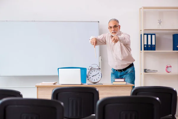 Παλιά αρσενικό δάσκαλος στην τάξη στην έννοια διαχείρισης του χρόνου — Φωτογραφία Αρχείου