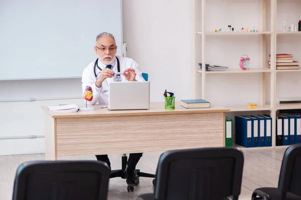 Velho professor de medicina do sexo masculino na sala de aula durante pandemia — Fotografia de Stock