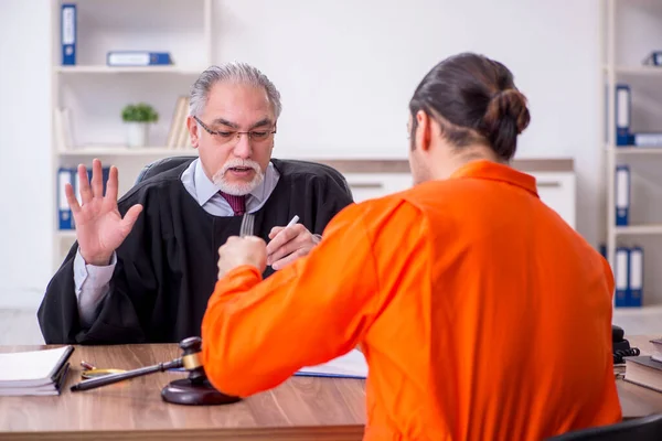 Vecchio giudice uomo incontro con giovane prigioniero in tribunale — Foto Stock