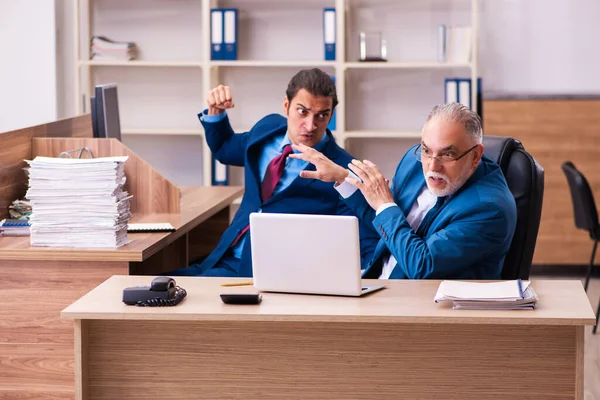 Old male boss and his young male assistant in bullying concept — Stock Photo, Image