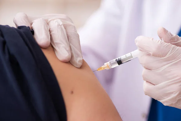 Gamle man besöker ung läkare i covid-19 vaccinering koncept — Stockfoto