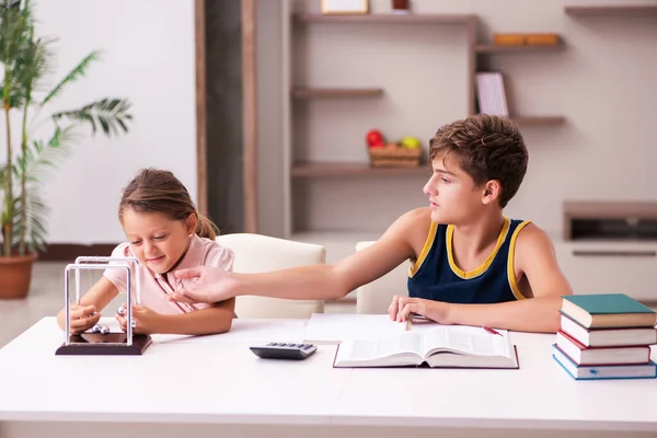 Skolpojke och hans lillasyster stannar hemma under pandemin — Stockfoto