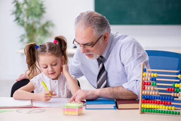 Oude leraar en schoolmeisje op school — Stockfoto