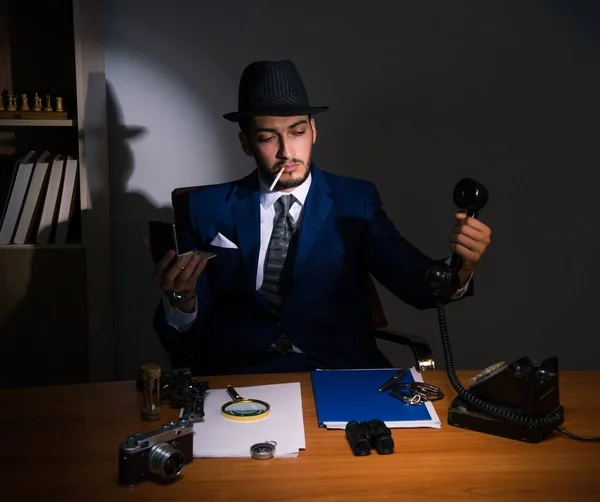 Detective sitting in dark room in vintage concept — Stock Photo, Image