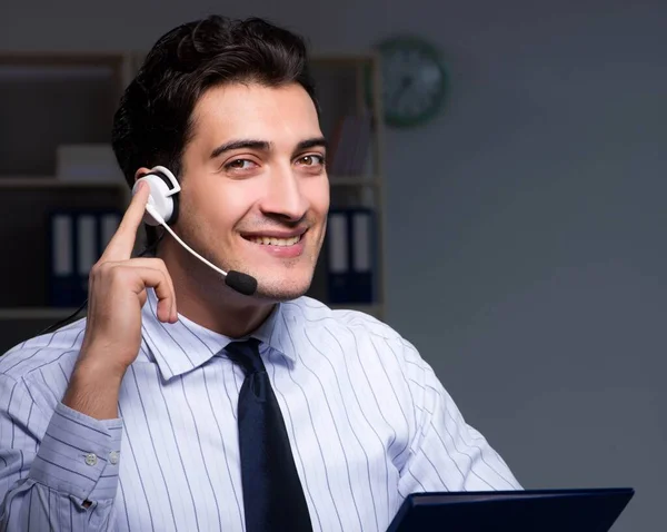 Operador de call center conversando com o cliente durante o turno da noite — Fotografia de Stock