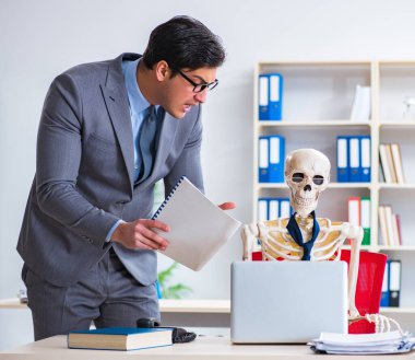 Kızgın patron iskelet çalışanına bağırıyor.