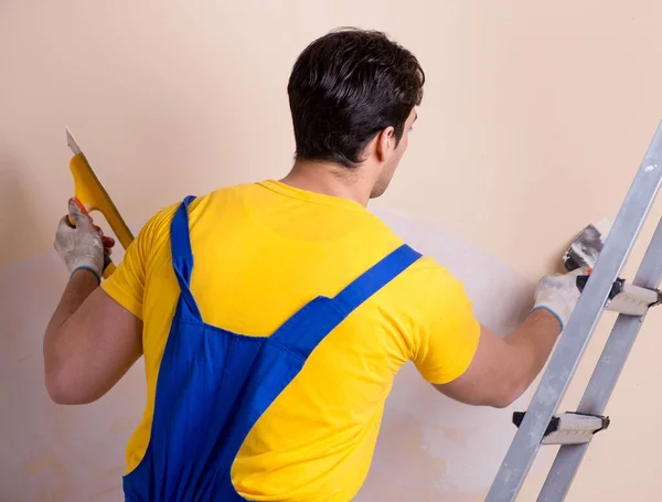 Empleado joven contratista aplicando yeso en la pared —  Fotos de Stock