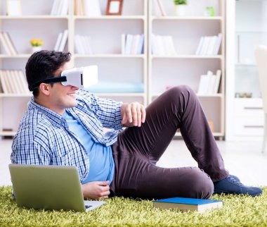 Evde sanal gerçeklik gözlükleriyle serbest çalışan bir öğrenci.