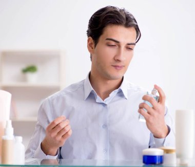 Adam banyoda çalışmak için giyiniyor.