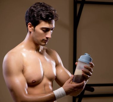 Spor salonunda besin takviyesi olan bir adam.