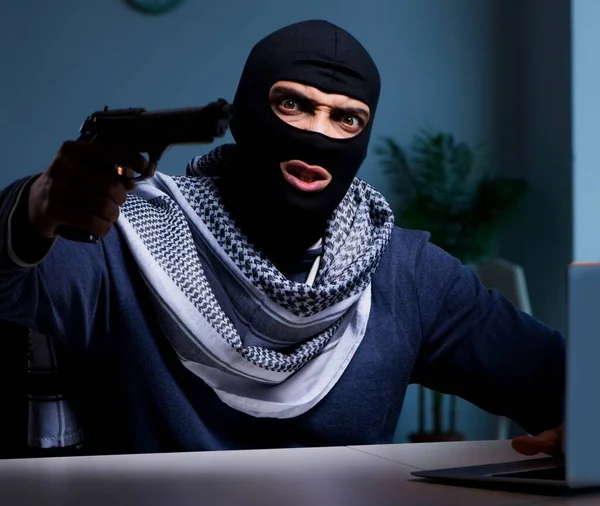 コンピュータで働いている銃を持つテロリストの強盗 — ストック写真