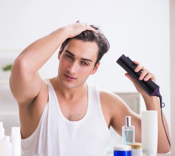 Молодой человек сушит волосы по утрам — стоковое фото