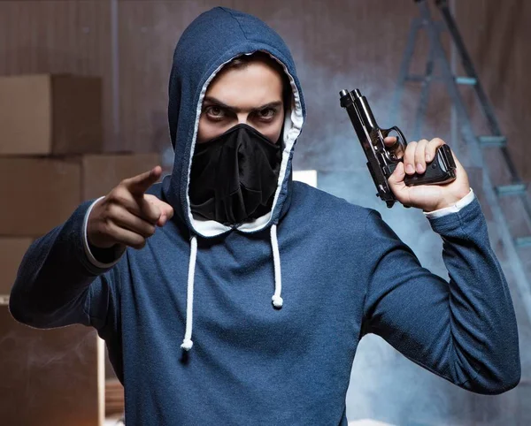 Uomo aggressivo con pistola indossando maschera — Foto Stock
