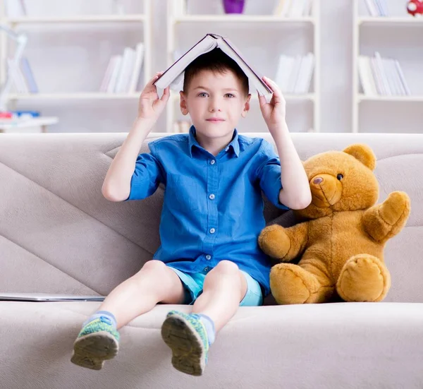 Evde kitap okuyan küçük bir çocuk. — Stok fotoğraf