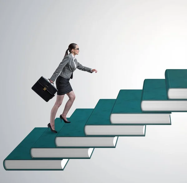 Студентка-предпринимательница, взбирающаяся по лестнице учебников — стоковое фото