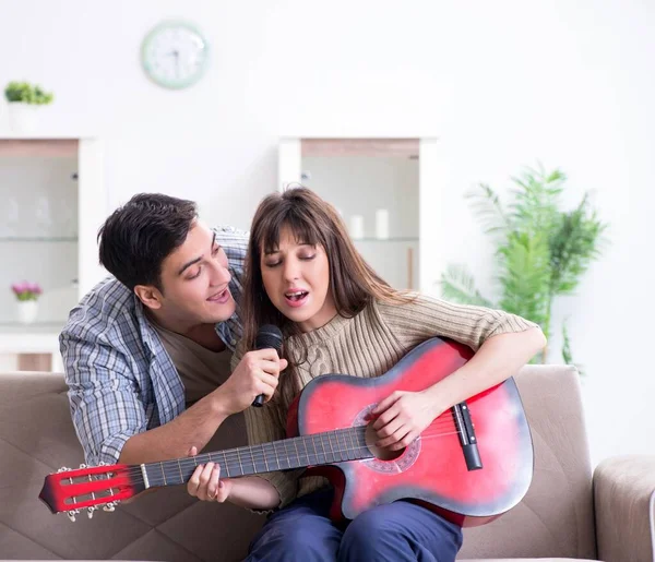 Joven familia cantando y tocando música en casa — Foto de Stock