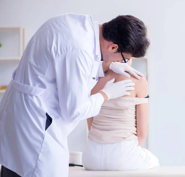 Médico examinando la piel de una paciente femenina — Foto de Stock