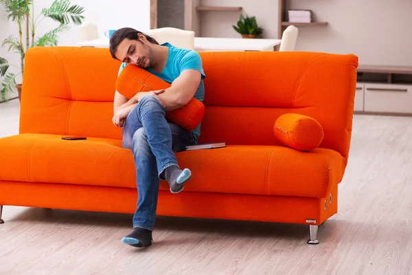 Joven estudiante masculino sentado en el sofá naranja — Foto de Stock