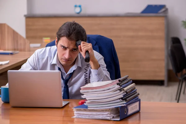 Joven empleado masculino descontento con el trabajo excesivo en la oficina — Foto de Stock