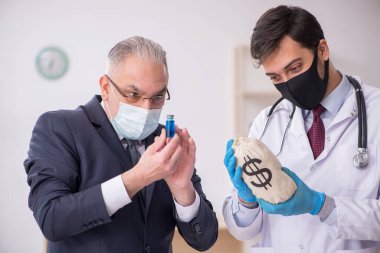 Yaşlı işadamı aşı danışmanıyla genç erkek doktoru ziyaret ediyor.