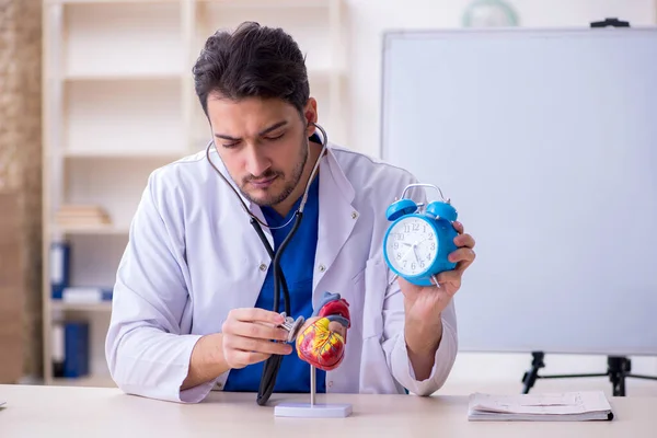 Zaman yönetimi konseptinde genç erkek doktor kardiyolog — Stok fotoğraf