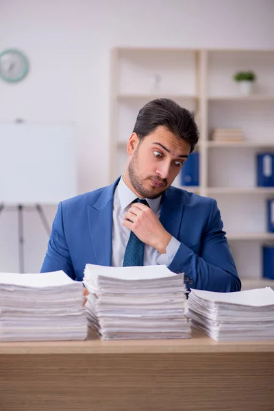 Joven empleado masculino descontento con el trabajo excesivo en la oficina — Foto de Stock