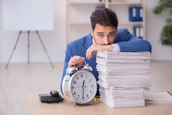 Giovane dipendente maschile nel concetto di gestione del tempo in ufficio — Foto Stock