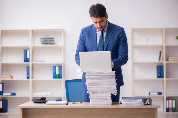 Junge männliche Angestellte unzufrieden mit exzessiver Arbeit im Büro — Stockfoto