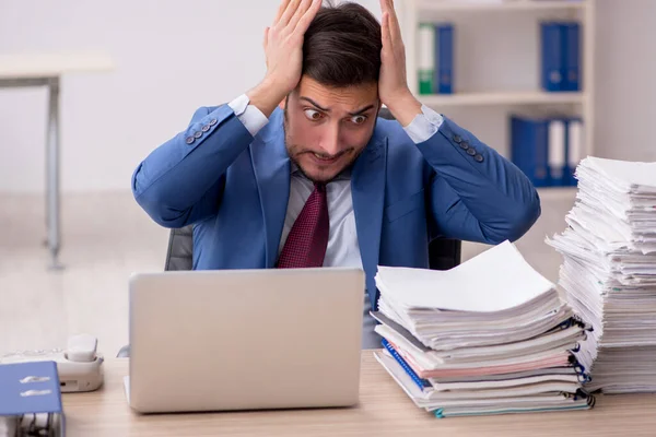 Junge männliche Mitarbeiter und zu viel Arbeit im Büro — Stockfoto