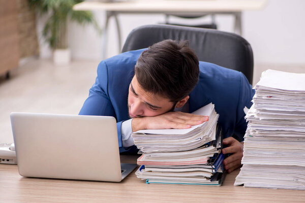 Молодой работник и слишком много работы в офисе