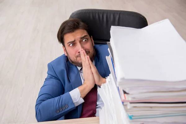 Junge männliche Mitarbeiter und zu viel Arbeit im Büro — Stockfoto