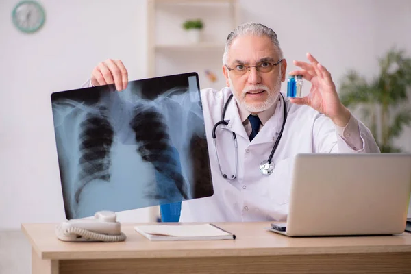Old male doctor radiologist working in the clinic — Stock Photo, Image