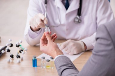 Genç işadamı aşı danışmanıyla yaşlı doktoru ziyaret ediyor.