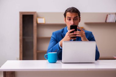 Genç erkek çalışan salgın sırasında evden çalışıyor.