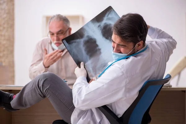 Idős férfi beteg látogató fiatal férfi orvos radiológus a p — Stock Fotó