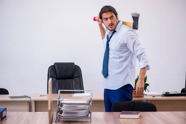 Junge männliche wütende Angestellte mit Beil im Büro — Stockfoto