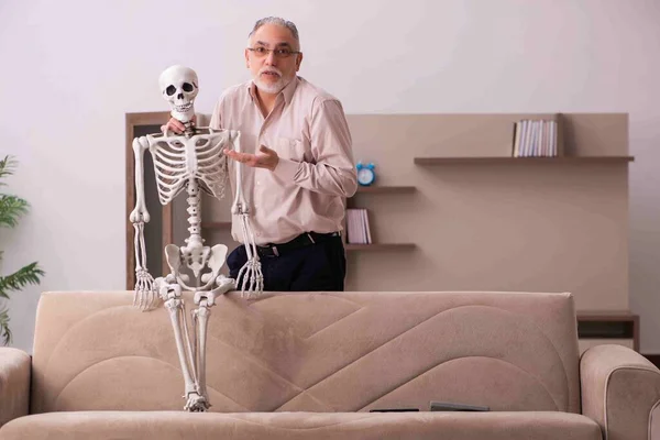Gubben sitter i soffan med det kvinnliga skelettet — Stockfoto