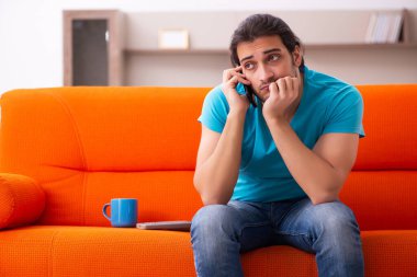 Genç erkek öğrenci salgın sırasında evde oturuyor.