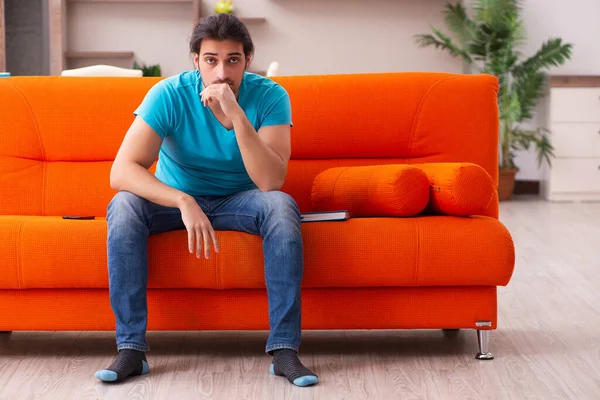 Joven estudiante masculino sentado en el sofá naranja — Foto de Stock