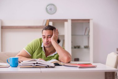 Evde sınava hazırlanan genç bir erkek öğrenci.