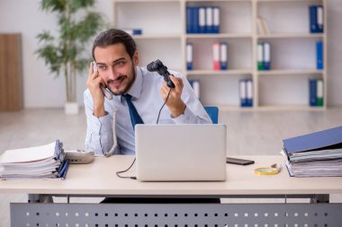 Genç bir erkek çalışan molada joystick oynuyor.